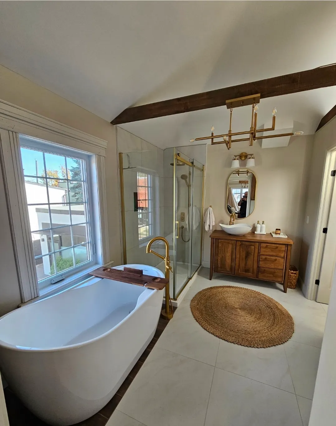 Salle de bain résidentielle terminée avec baignoire, douche vitrée et meuble-lavabo